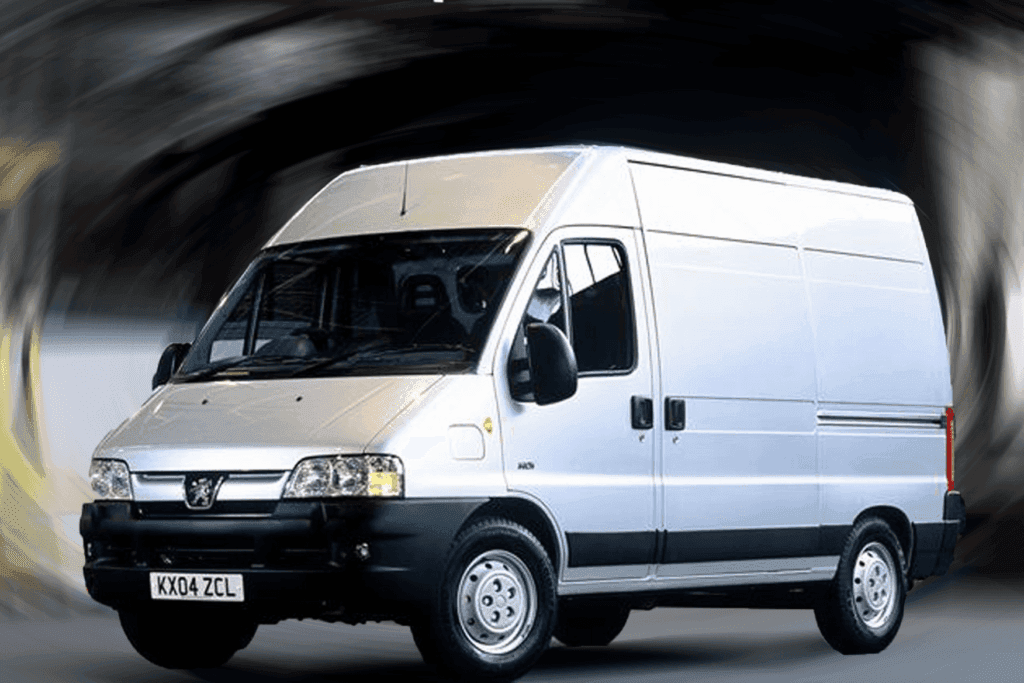 A white cargo van with a blurred background, showcasing the vehicle's front and side view. The van is stationary and displays the registration plate 'kx04 zcl'.