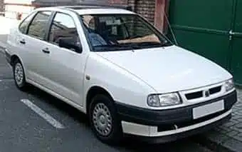 A white compact saloon parked on a road, featuring a clean design with no visible modifications, and a dark trim around the base.